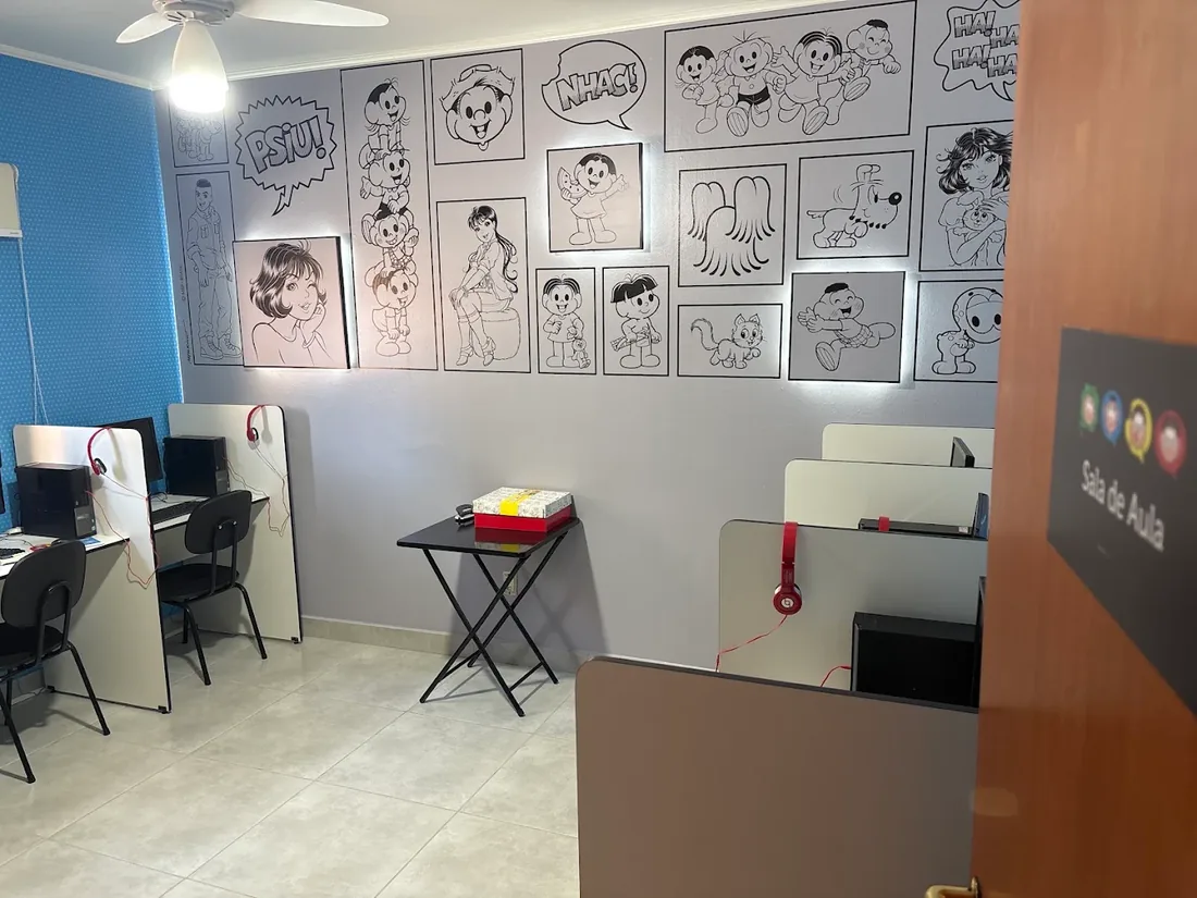 Sala de aula com estações individuais de computador e fones de ouvido
